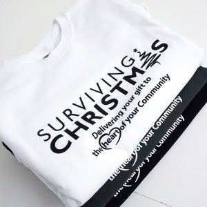 Photo of white, grey and black t-shirts with Surviving Christmas charity branding