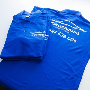 Photo of royal blue polo shirts with Vehicle Solutions car body repair business branding