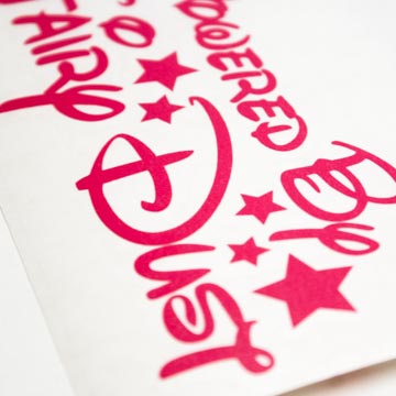 Photo of pink vinyl sticker with Powered By Fairy Dust funny design